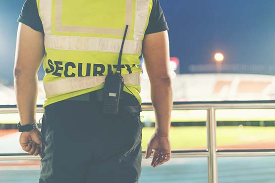 Sicherheitsdienst mit Weste und Funkgerät im Stadion